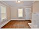 Bright living space with hardwood flooring, a white painted fireplace, and a window for natural light at 2017 Ashley Rd, Charlotte, NC 28208
