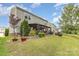 Beautiful backyard with mature trees, landscaping, covered patio, fire pit, and ample lawn space at 2037 Christopher Wood Ct, Fort Mill, SC 29707