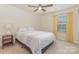 Bright bedroom with a patterned bedspread, side table, and a window with curtains at 2037 Christopher Wood Ct, Fort Mill, SC 29707