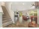 Open-concept living area featuring staircase access, wood-look floors, and ceiling fan at 2037 Christopher Wood Ct, Fort Mill, SC 29707