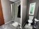 A bathroom with a shower, toilet, and grey tile flooring at 226 Lake Sylvia Rd, Lincolnton, NC 28092
