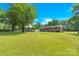 Expansive backyard showcasing a lush green lawn with mature trees and a fenced perimeter for privacy at 2323 Brookwood Rd, Lincolnton, NC 28092