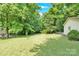 A grassy lawn, mature trees, and partial views of the house, all in a well-maintained backyard at 2323 Brookwood Rd, Lincolnton, NC 28092