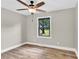 Bright bedroom features wood-look floors, neutral walls and ceiling fan, with a view to the yard at 2323 Brookwood Rd, Lincolnton, NC 28092