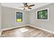 Bright bedroom features wood-look floors and views through two windows to the landscaped exterior at 2323 Brookwood Rd, Lincolnton, NC 28092