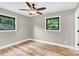 Bright bedroom features wood-look floors and views through two windows to the landscaped exterior at 2323 Brookwood Rd, Lincolnton, NC 28092