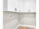 Bright laundry room showcasing white cabinets, sleek black hardware, and wood-look flooring at 2323 Brookwood Rd, Lincolnton, NC 28092