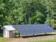 View of the Solar Panels and adjacent shed, set among mature trees at 2905 Medlin Rd # 40 Acres, Monroe, NC 28112