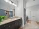 Bathroom with dual vanities, granite countertops, a large mirror, and tiled floors at 3007 Arsdale Rd, Waxhaw, NC 28173