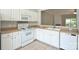 Updated kitchen offers white cabinets, a tile floor, and a view to the living room at 3014 Castleberry Ct, Charlotte, NC 28209