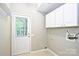Functional laundry room with white cabinets and access to the outside at 3014 Castleberry Ct, Charlotte, NC 28209
