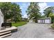 View of the backyard features a home, an outdoor garage, a small deck, a gravel driveway, and green lawn at 310 S Jacob St, Cherryville, NC 28021