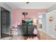 Bright bedroom featuring pink walls, wood floors, and gray dresser with television at 310 S Jacob St, Cherryville, NC 28021