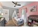 Cozy bedroom featuring a toddler bed with a sheer canopy, light wood floors, and an overhead fan at 310 S Jacob St, Cherryville, NC 28021