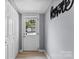 Bright entryway with a wooden floor and a white door leading outside, with a 'Home Sweet Home' wall decoration at 310 S Jacob St, Cherryville, NC 28021