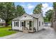 Quaint house with white siding, a metal roof, and a welcoming front porch with a small seating area at 310 S Jacob St, Cherryville, NC 28021