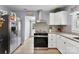 Kitchen featuring stainless steel appliances, white cabinets, and decorative backsplash at 310 S Jacob St, Cherryville, NC 28021