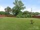 Large, well-maintained backyard featuring a spacious green lawn and mature trees at 3408 Oak Tree Trl, Matthews, NC 28105