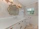 Bathroom featuring decorative mirror and light fixtures, vanity with storage and elegant wallpaper at 3408 Oak Tree Trl, Matthews, NC 28105
