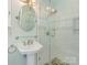 Bright bathroom featuring a pedestal sink and a glass-enclosed shower with decorative tile accents at 3408 Oak Tree Trl, Matthews, NC 28105