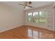 Bright room with hardwood floors, large windows, ceiling fan, and built-in shelves for ample storage at 3408 Oak Tree Trl, Matthews, NC 28105