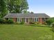 Charming brick ranch home with manicured lawn and mature landscaping at 3408 Oak Tree Trl, Matthews, NC 28105