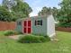 Well-maintained outdoor shed with bright red doors and black shuttered windows, surrounded by healthy green foliage at 3408 Oak Tree Trl, Matthews, NC 28105