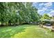 Large backyard with green grass, a swingset, and a patio seating area at 3702 Brookstone Trl, Indian Trail, NC 28079