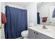 Cozy bathroom featuring a grey vanity, toilet, and a navy blue shower curtain at 3702 Brookstone Trl, Indian Trail, NC 28079