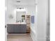 Well-lit bathroom with modern vanity, decorative shelving, and bathtub with shower at 3702 Brookstone Trl, Indian Trail, NC 28079