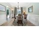 Well-lit dining room featuring elegant wainscoting, hardwood floors, and large windows providing natural light at 3702 Brookstone Trl, Indian Trail, NC 28079