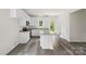 This open kitchen features white cabinets, stainless appliances, a center island, and hard surface floors at 510 3Rd St, Salisbury, NC 28144