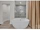 Elegant soaking tub next to a glass enclosed shower at 513 Meadow Ridge Dr, Belmont, NC 28012