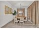 A dining room features a wooden table, seating for six, hardwood floors, tan curtains, and art decorated on the walls at 513 Meadow Ridge Dr, Belmont, NC 28012