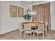 A dining room features a wooden table, seating for six, hardwood floors, tan curtains, and art decorated on the walls at 513 Meadow Ridge Dr, Belmont, NC 28012