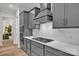 Modern kitchen with gray cabinets, island cooktop, stainless appliances, and herringbone backsplash at 513 Meadow Ridge Dr, Belmont, NC 28012