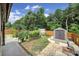 Landscaped backyard with fenced yard, tool shed, raised garden beds, and stone patio at 5424 Tilley Manor Dr, Matthews, NC 28105