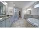 Bright bathroom with dual vanities, granite countertops, soaking tub, and tiled flooring at 5424 Tilley Manor Dr, Matthews, NC 28105