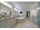 Bathroom featuring double vanities, granite countertops, tiled floors, and a soaking tub at 5424 Tilley Manor Dr, Matthews, NC 28105