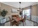 Inviting dining room with natural light, wood table, and elegant chandelier at 5424 Tilley Manor Dr, Matthews, NC 28105