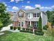 Charming two-story home with manicured lawn, stone accents, and a welcoming American flag at 5424 Tilley Manor Dr, Matthews, NC 28105