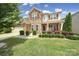 Charming two-story home with a brick and stone facade, well-manicured landscaping, and a two-car garage at 5424 Tilley Manor Dr, Matthews, NC 28105
