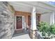 Inviting front porch with decorative wreath, welcome sign, and stone pillar accents at 5424 Tilley Manor Dr, Matthews, NC 28105