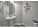 Stylish powder room with pedestal sink, decorative mirror, and modern fixtures at 5424 Tilley Manor Dr, Matthews, NC 28105
