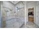 Walk-in shower showcasing tile surround, glass door, and built-in bench at 5424 Tilley Manor Dr, Matthews, NC 28105