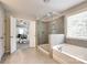 Stunning bathroom has a glass shower, garden tub, and tiled floor that connects to the main bedroom at 5635 Agora Ct, Lancaster, SC 29720