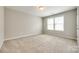 Bright bedroom features neutral walls, plush carpet, and a large window with natural light at 5635 Agora Ct, Lancaster, SC 29720