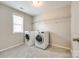 Laundry room includes tiled floors, storage shelves, and modern washer and dryer at 5635 Agora Ct, Lancaster, SC 29720