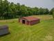 Aerial view of the barn and outbuilding on sprawling green land at 5958 Hoover Elmore Rd, Lincolnton, NC 28092
