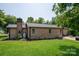 Brick home featuring green lawn, trees, a back patio, and a charming doghouse at 5958 Hoover Elmore Rd, Lincolnton, NC 28092